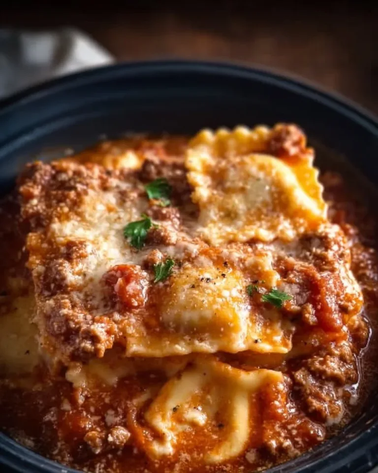 Crockpot Ravioli Lasagna served in a dish, showcasing layers of cheese and ravioli.