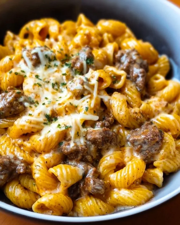 Creamy beef and cheese pasta dish garnished with herbs