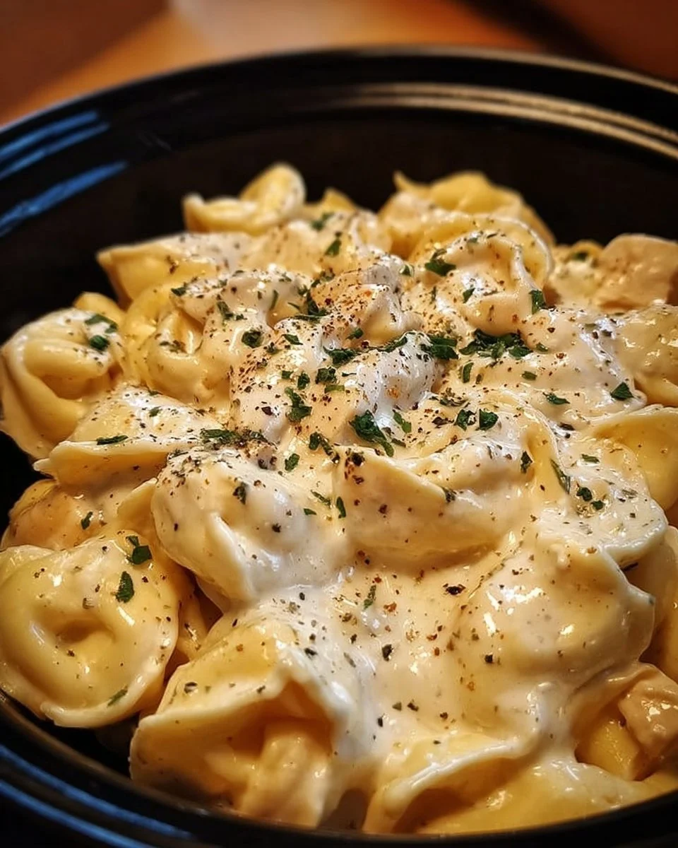 Creamy crockpot chicken alfredo tortellini served in a bowl