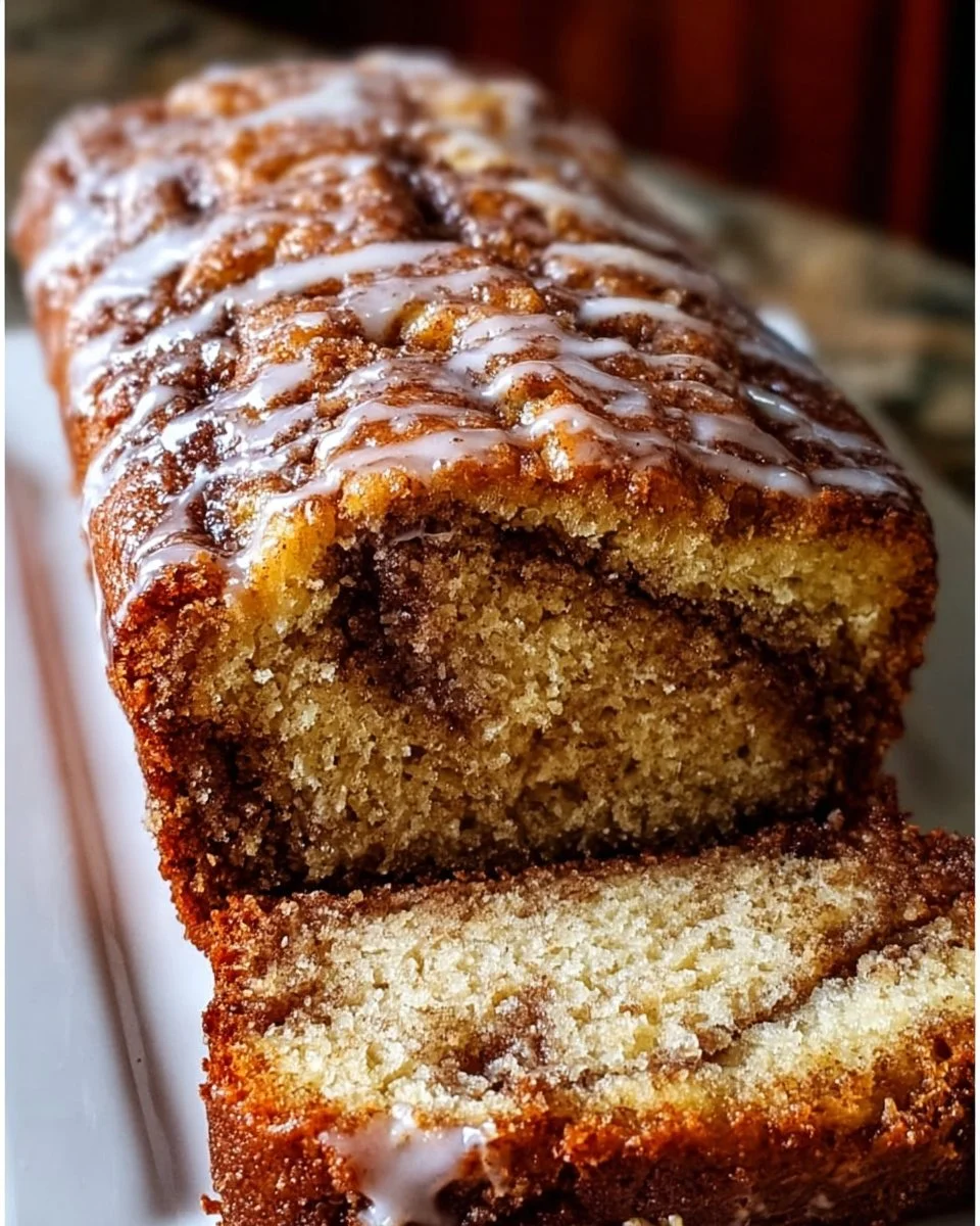 Loaf of homemade cinnamon swirl banana bread with slices cut on a wooden board